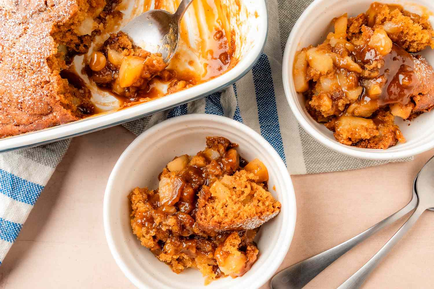 Baked pear pudding cake served in bowls with spoons