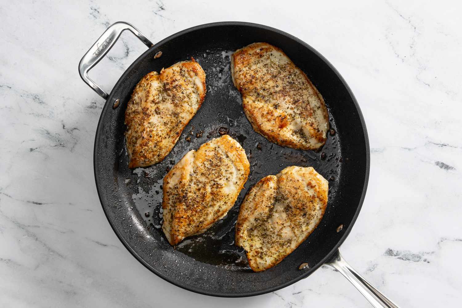 chicken cutlets cooked in a pan for creamy tuscan chicken recipe