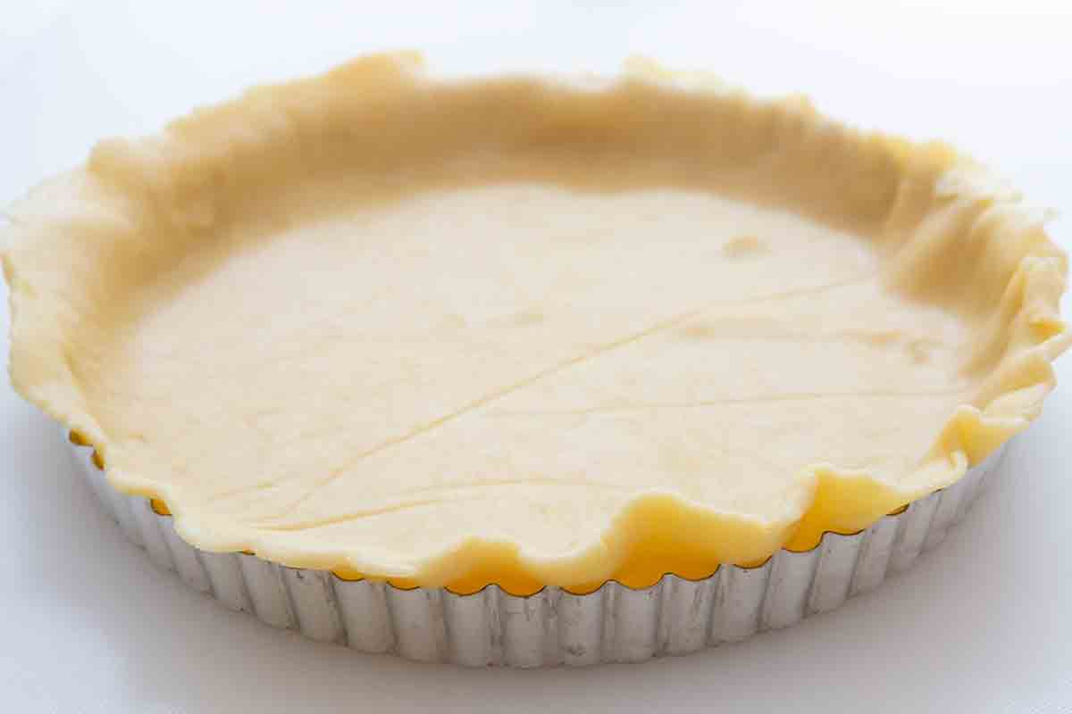 Press rolled out lemon tart dough into tart pan