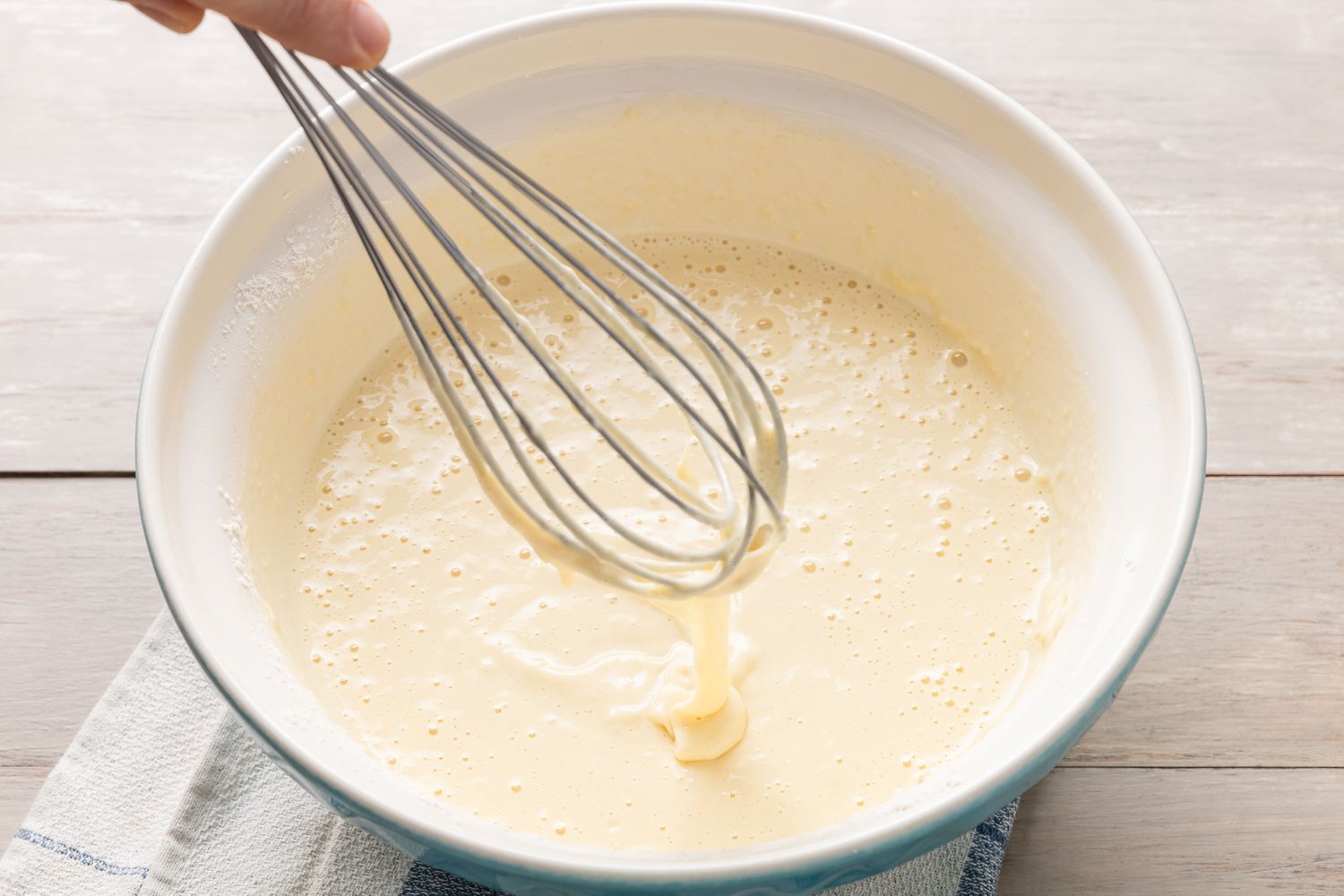 Pannenkoeken (Dutch Pancakes) batter lifted up using a whisk to check consistency