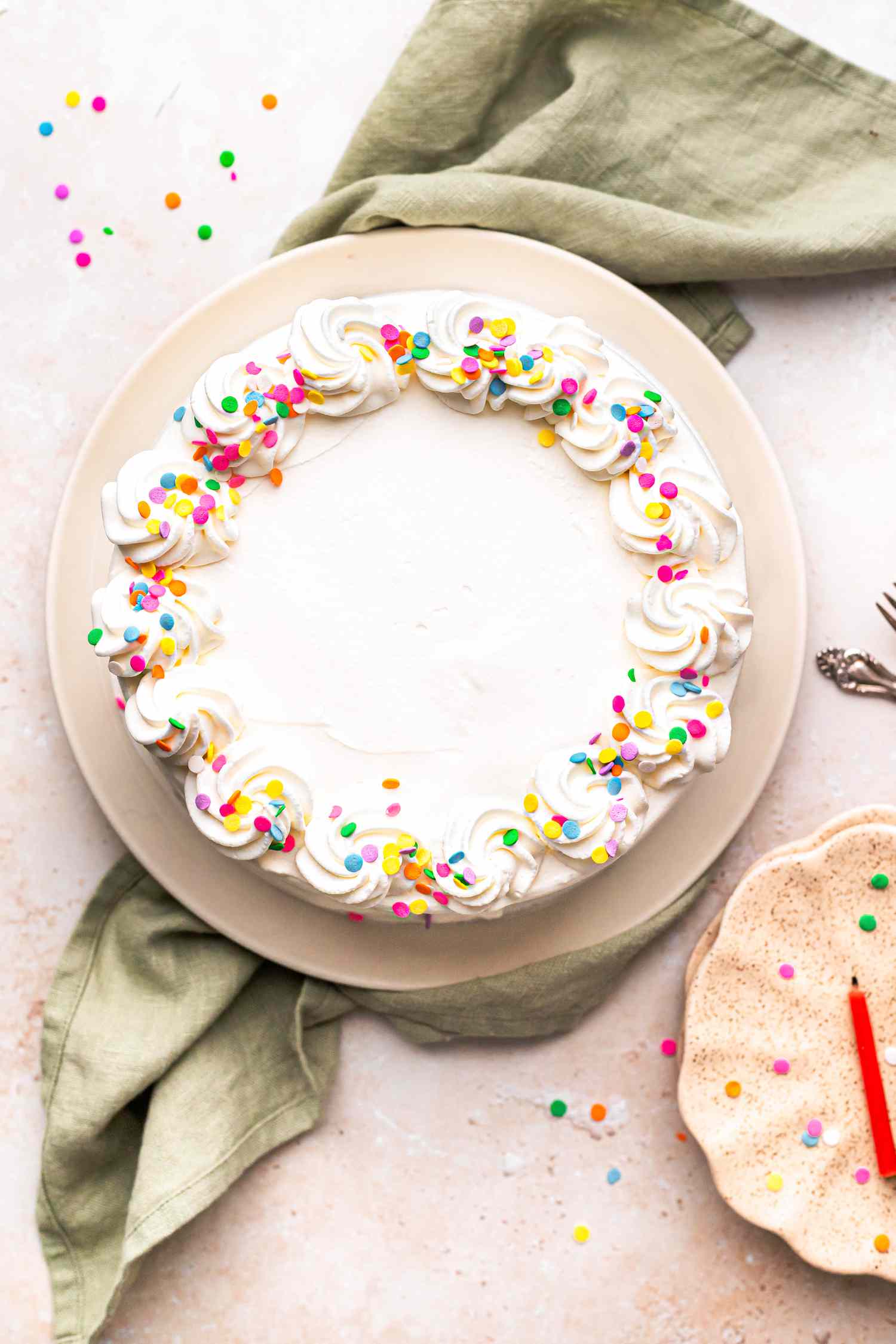 Ice Cream Cake on Plate Next to Smaller Plates with a Candle on It 