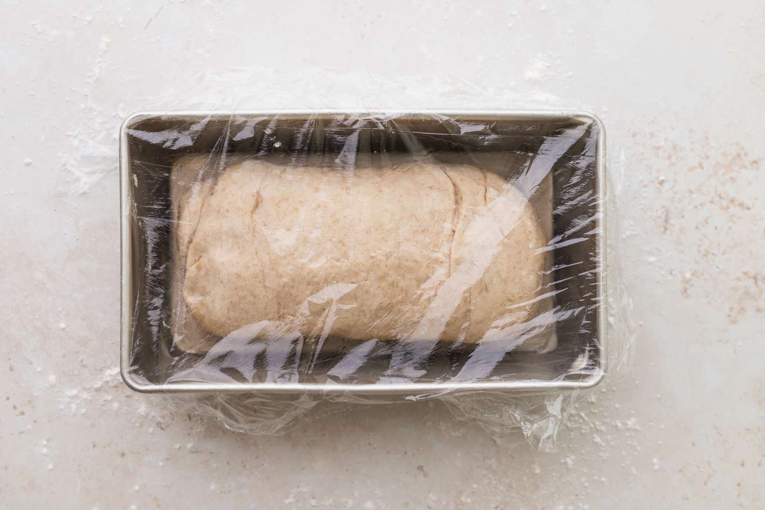 Oat bread loaf rising in a loaf pan.