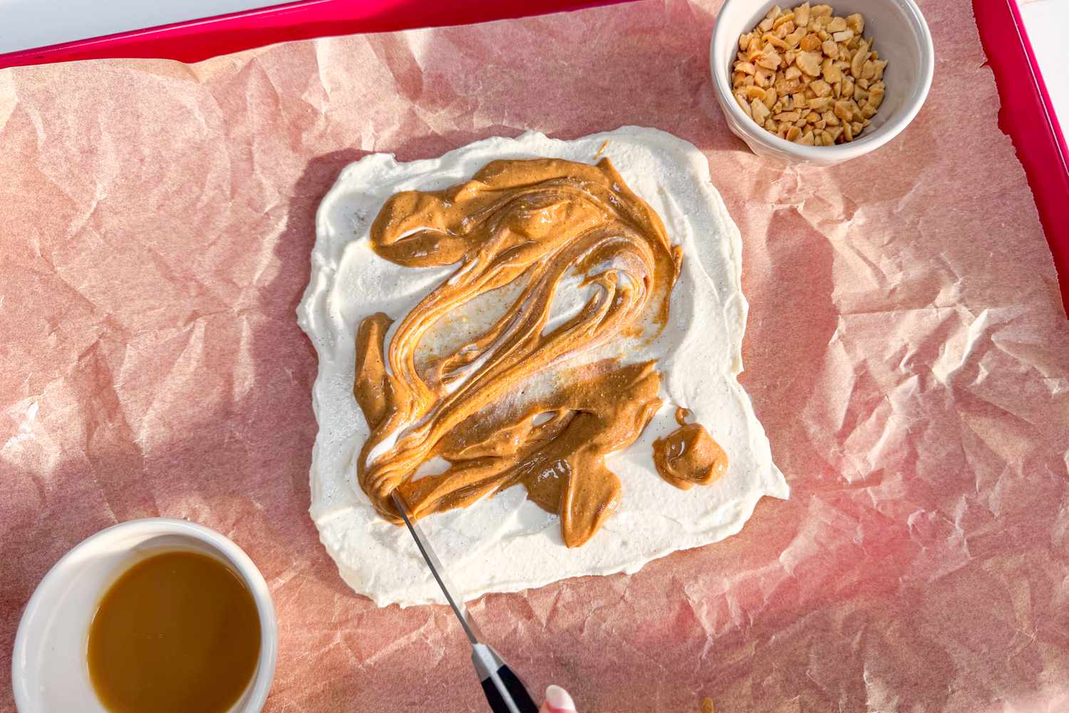 Spread of cream and peanut butter on parchment, surrounded by small bowls
