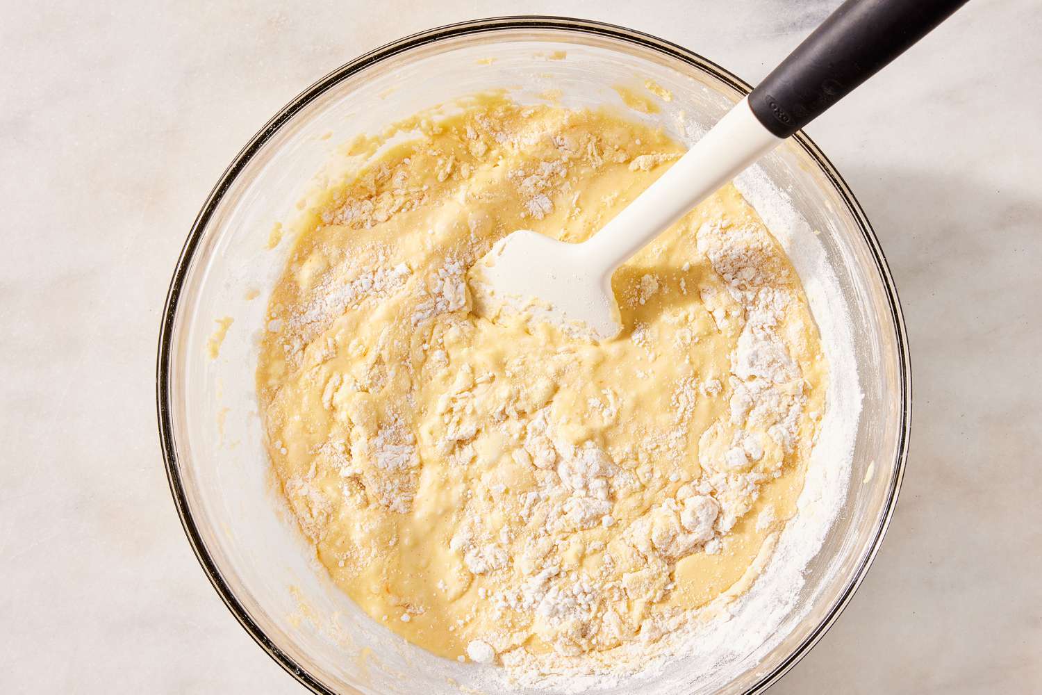 dry ingredients with wet ingredients added in a bowl with a spatula for Sock It to Me Cake