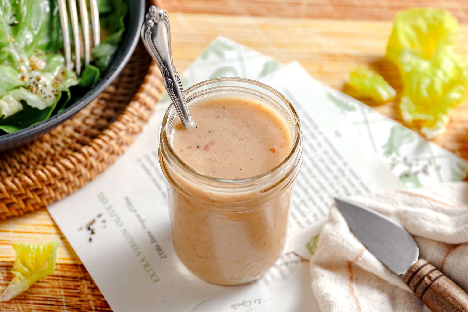 Salad dressing in a cup with a spoon sticking out of it