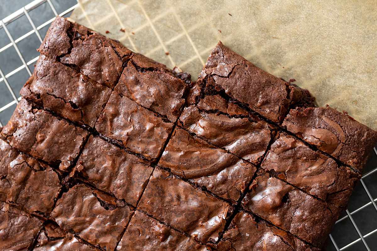 Brownies cut into slices and cooling on a rack.