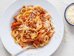 Pasta with bolognese sauce on a white plate.