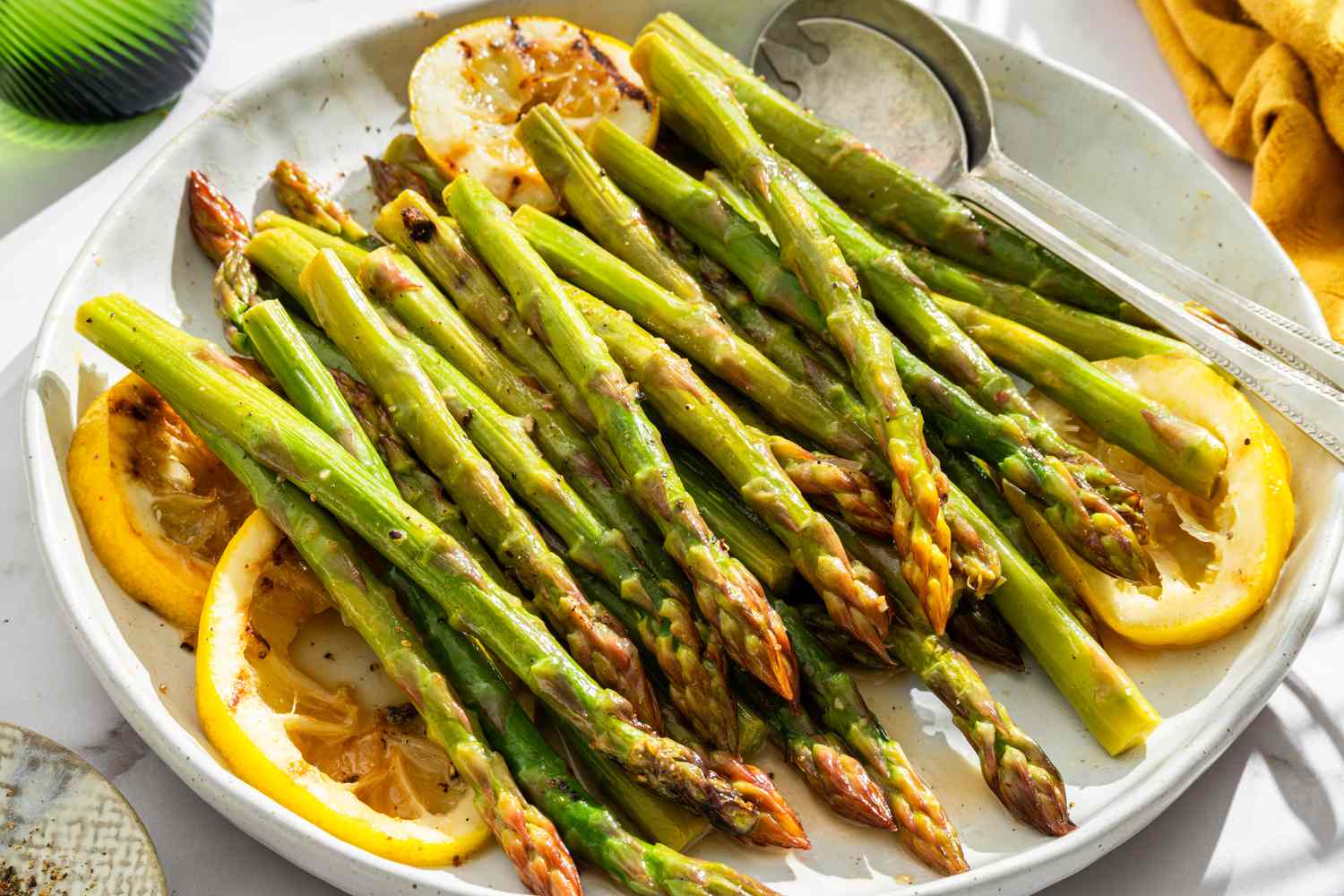 Grilled asparagus with lemon slices on a plate
