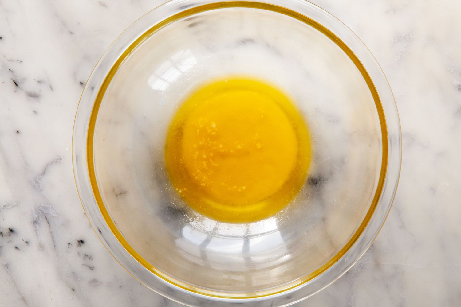 Making the filling for chocolate pecan pie with bourbon in a glass bowl.