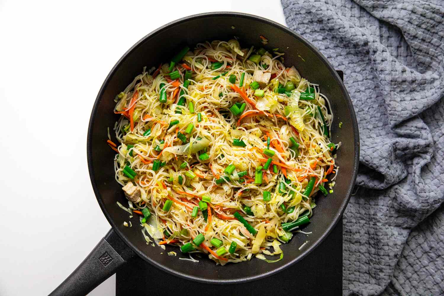 Salt and Pepper Added to Pancit Bihon (Filipino Rice Noodles) in a Wok