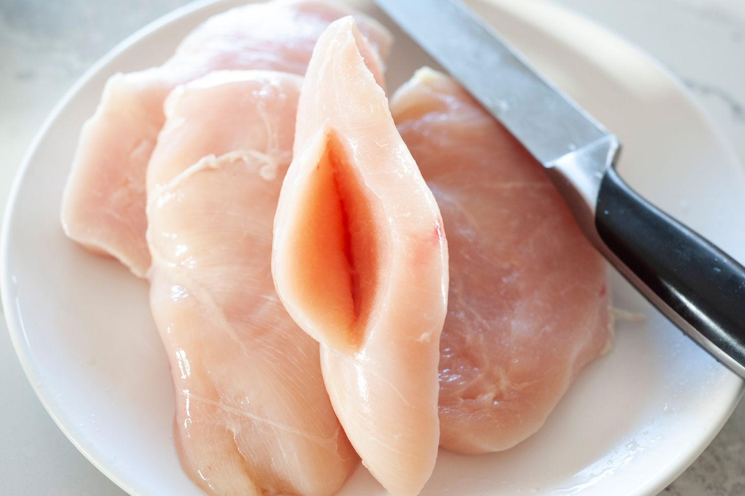 Slice pocket into chicken thigh.