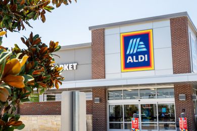 A view of the storefront of an Aldi supermarket, showing signs and the entrance