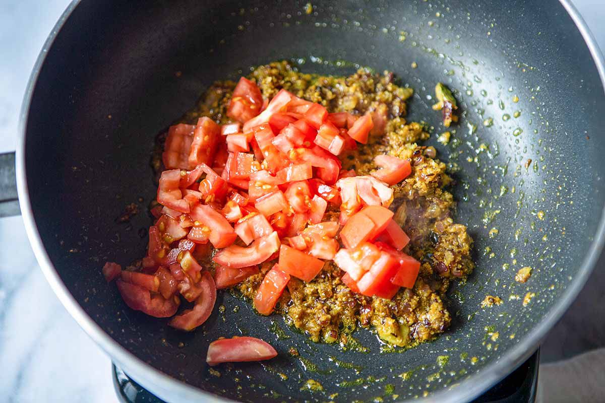 Indian Chana Masala Recipe - spices, oil, onion and tomato in pan