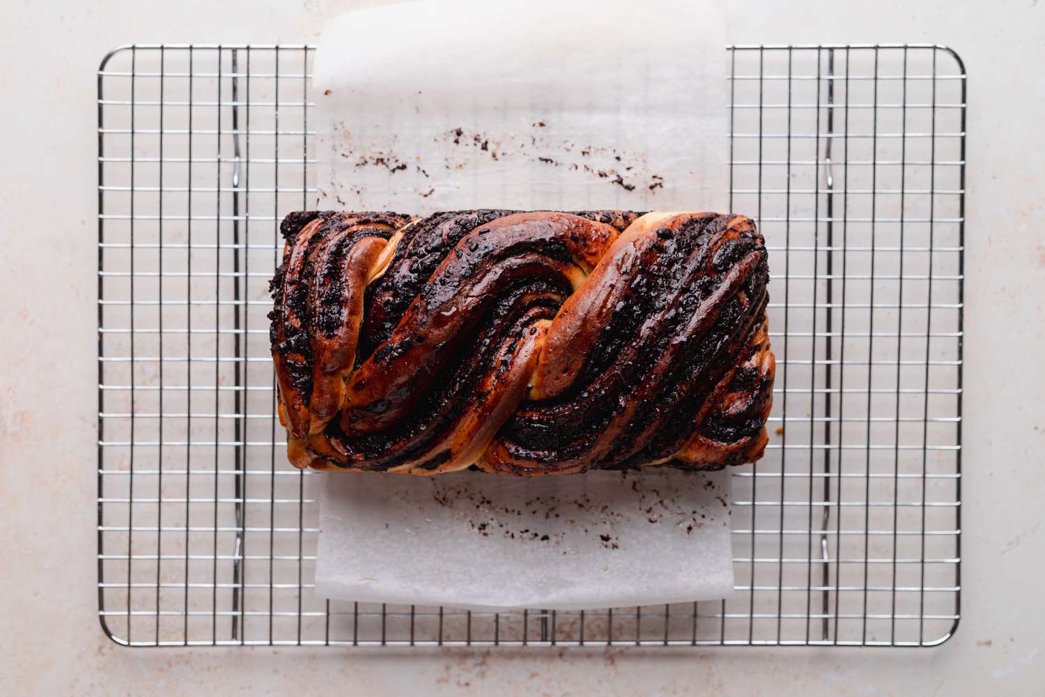 Braided chocolate babka cooling on a rack.