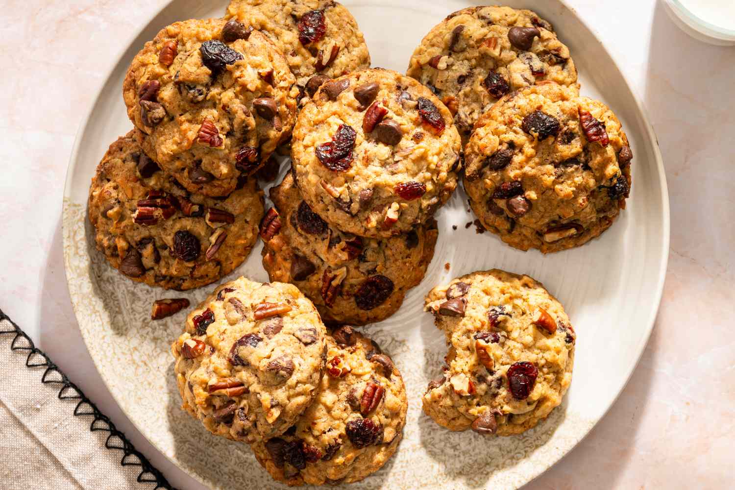 A plate of ranger cookies with chocolate chips and dried fruit