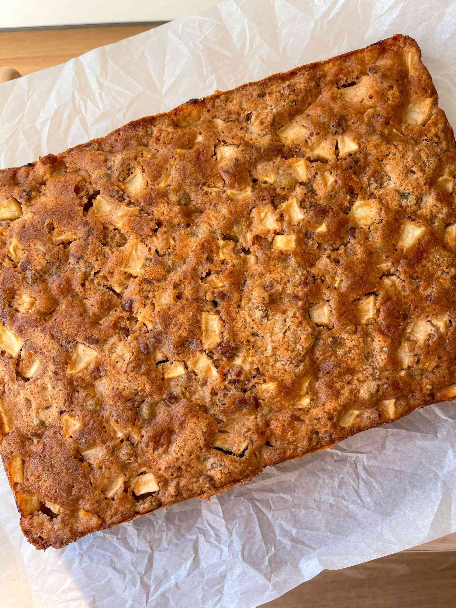 Ina Garten's spiced apple cake (uncut) on a piece of parchment paper