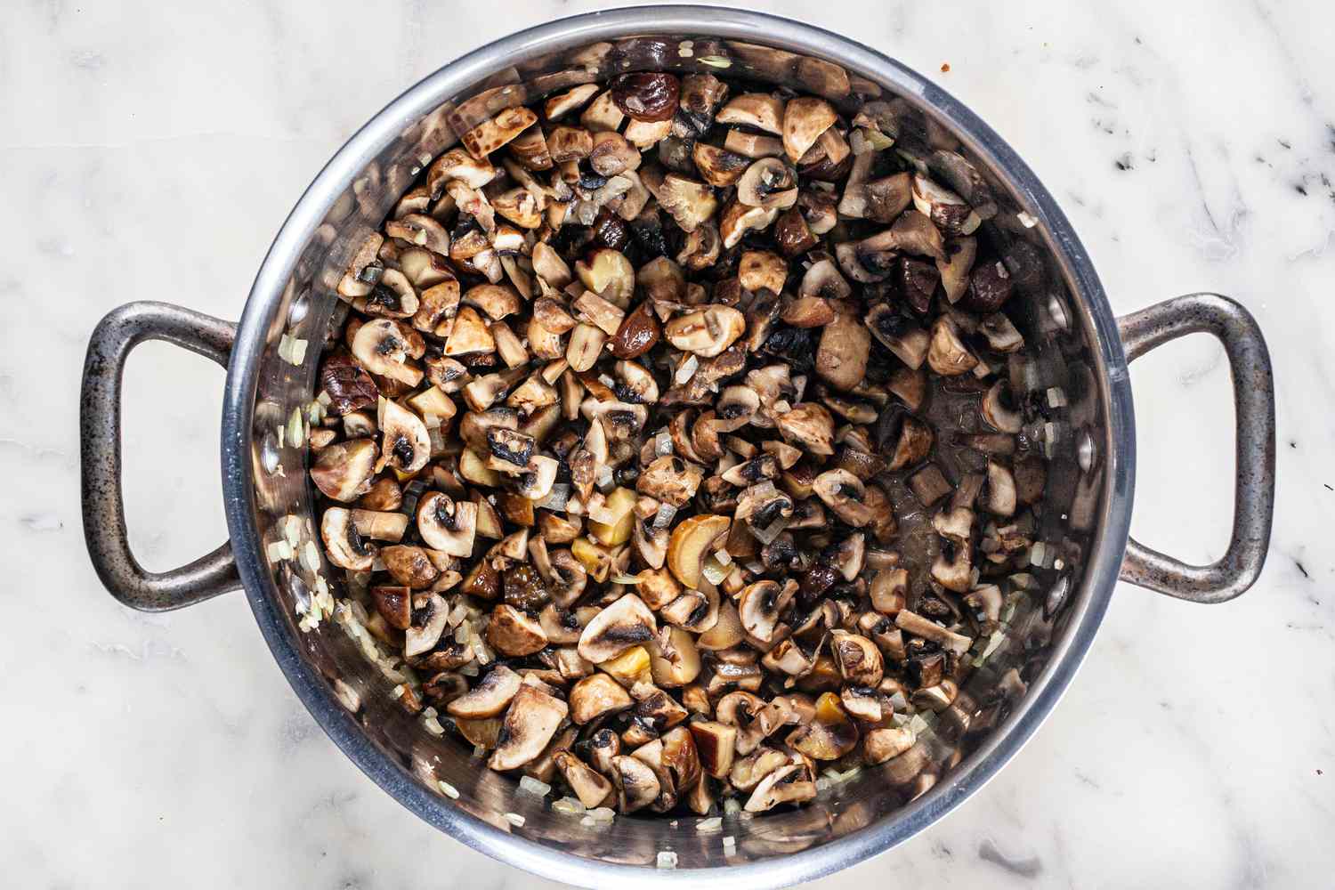 Mushrooms in a large stockpot to make creamy chestnut and cremini soup