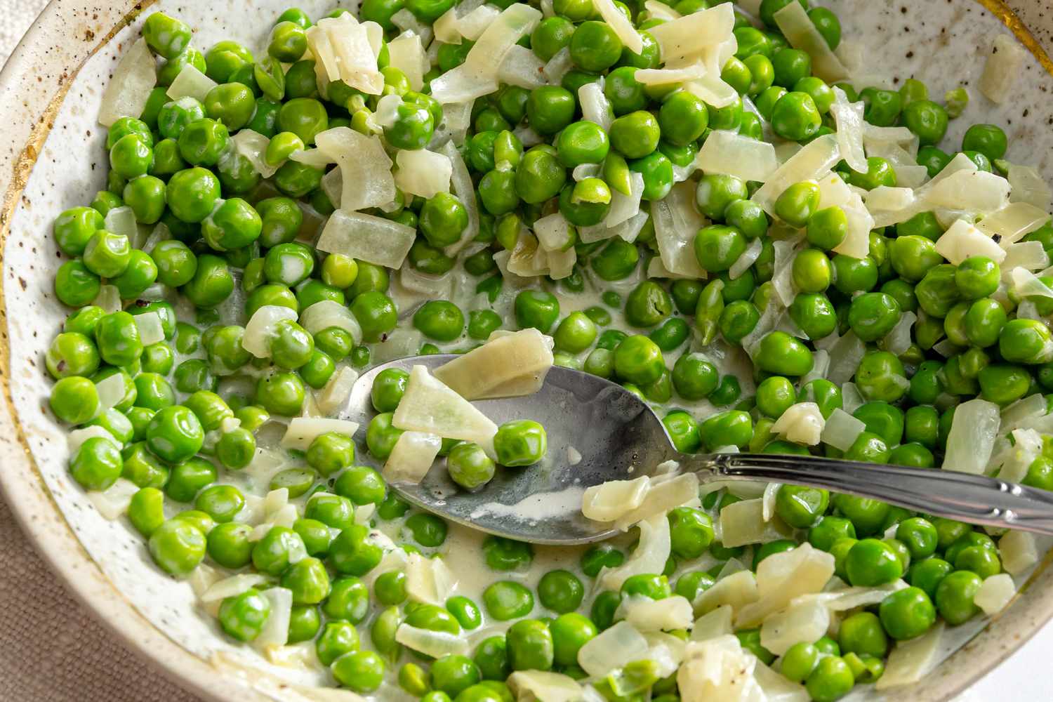 Creamed Peas in a bowl with a spoon close-up