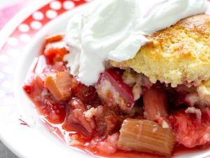 Bowl of Strawberry Rhubarb Cobbler Topped With Whipped Cream