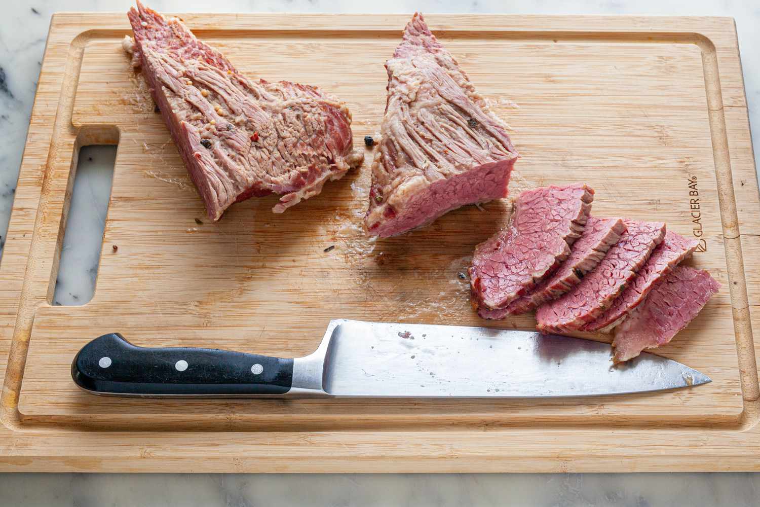 Slicing boiled corned beef from a New England Boiled Dinner recipe