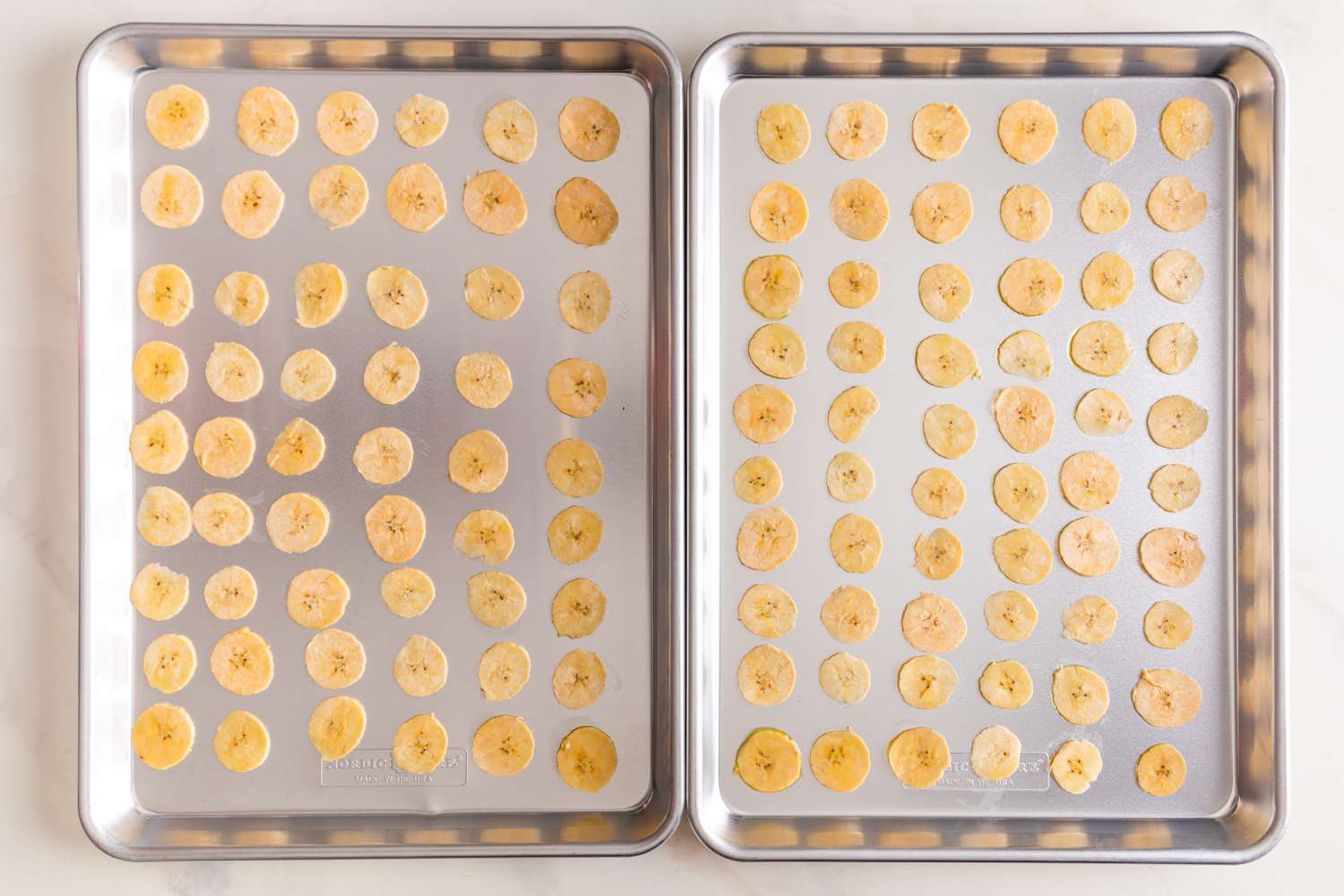 Rows of Sliced Plantains on Two Baking Sheets