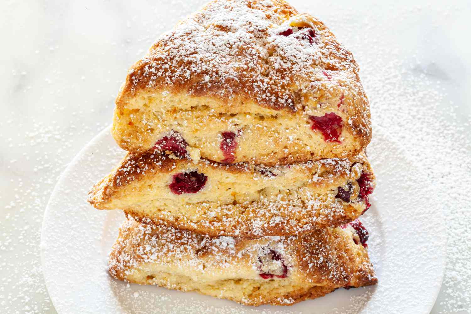 A stack of three cranberry scones on a plate
