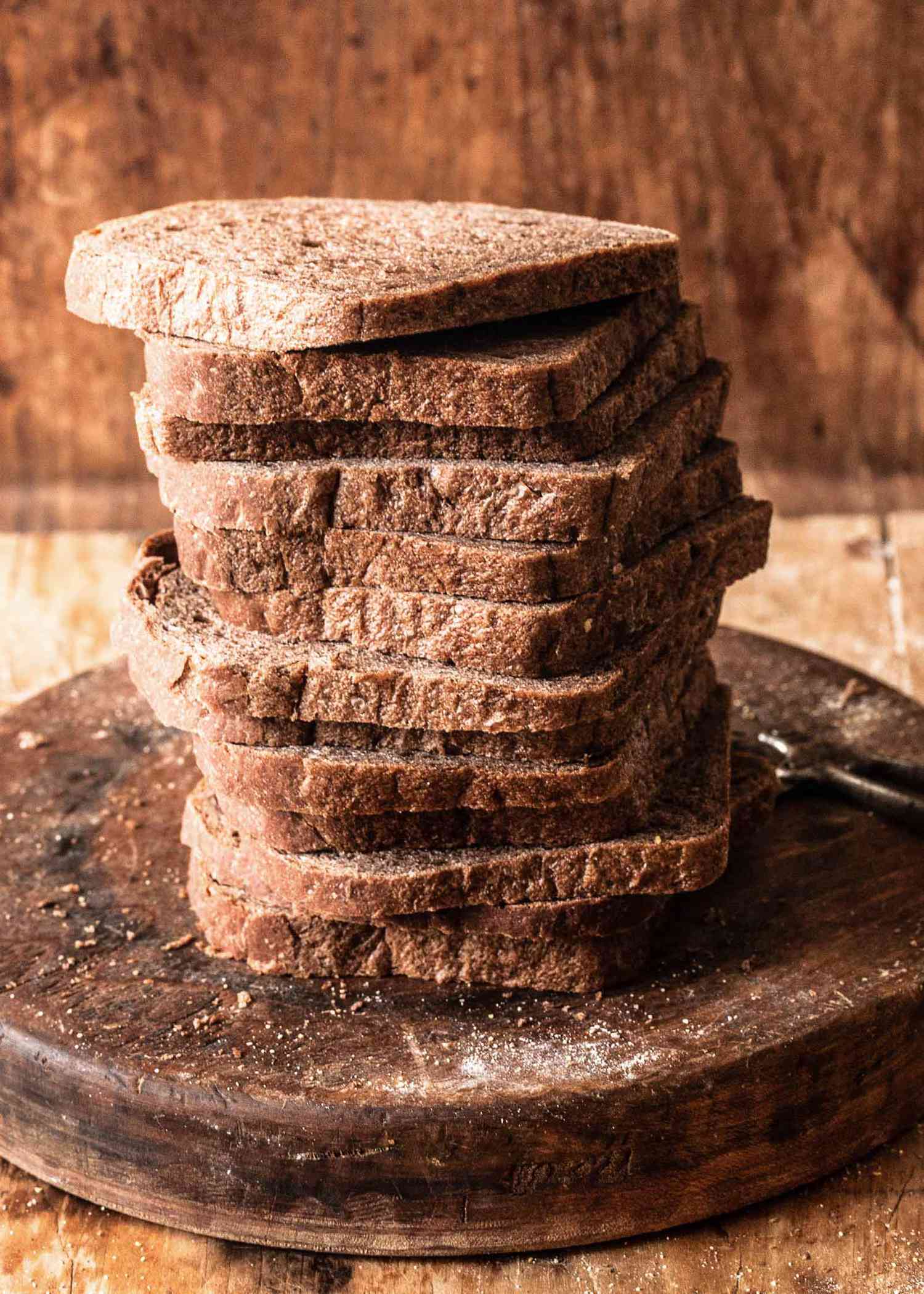 A stack of slicked homemade rye bread slices on a board