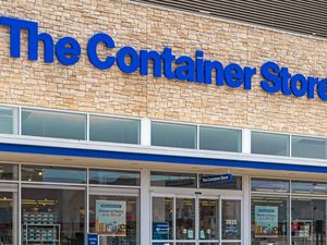 The exterior of The Container Store showing its signage above glass storefront windows and entrance