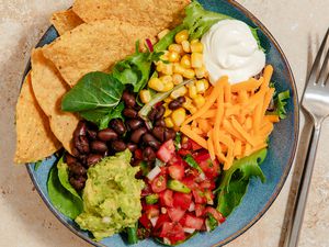 bowl of black bean nacho salad with a dollop of sour cream