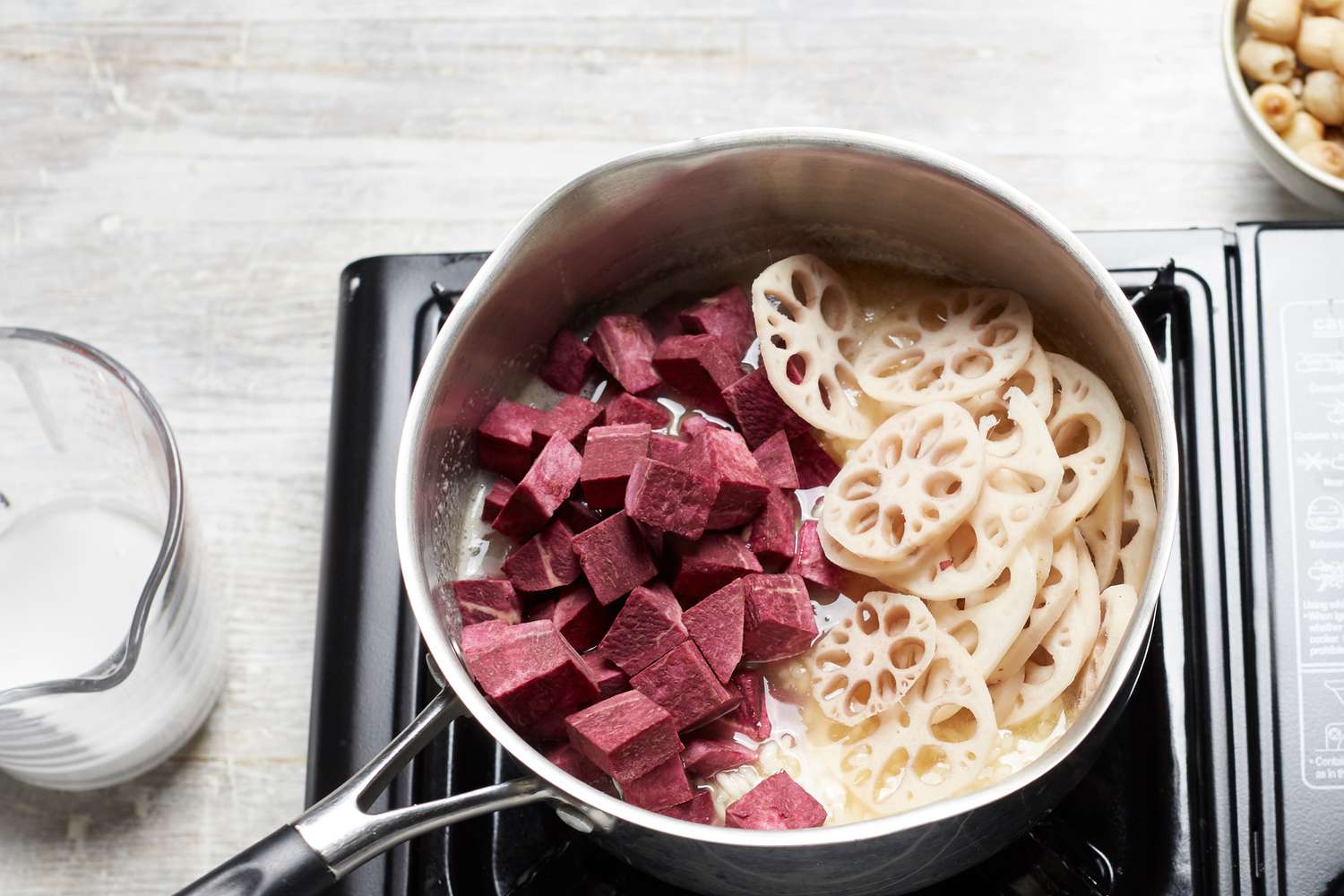 Sliced lotus and chopped sweet potato in a pot to make easy coconut rice pudding with lotus and sweet potato 