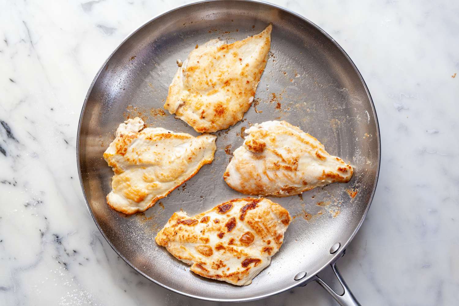 Brown chicken cutlets in skillet.