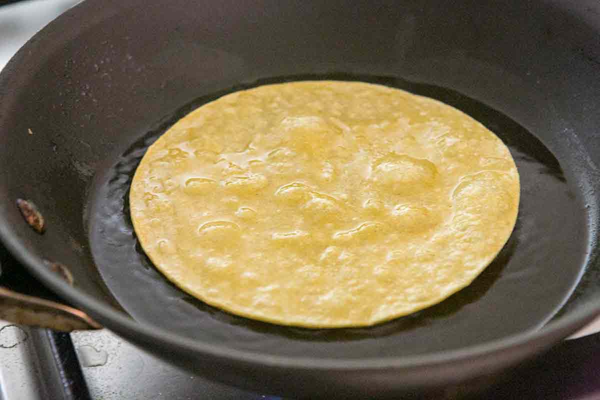 Making chicken enchiladas with yellow corn tortillas