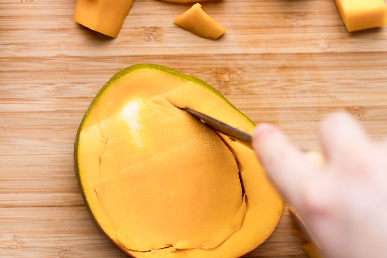 Cutting a mango seed out of the fruit.