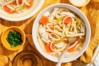 Bowl of chicken noodle soup at a table setting
