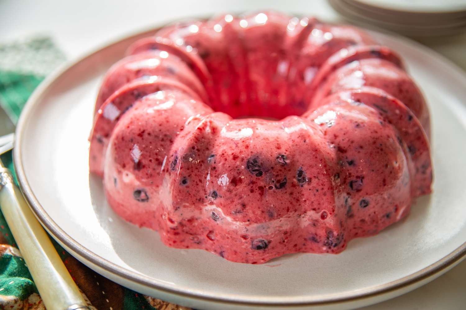 A circular blueberry gelatin mold dessert served on a plate