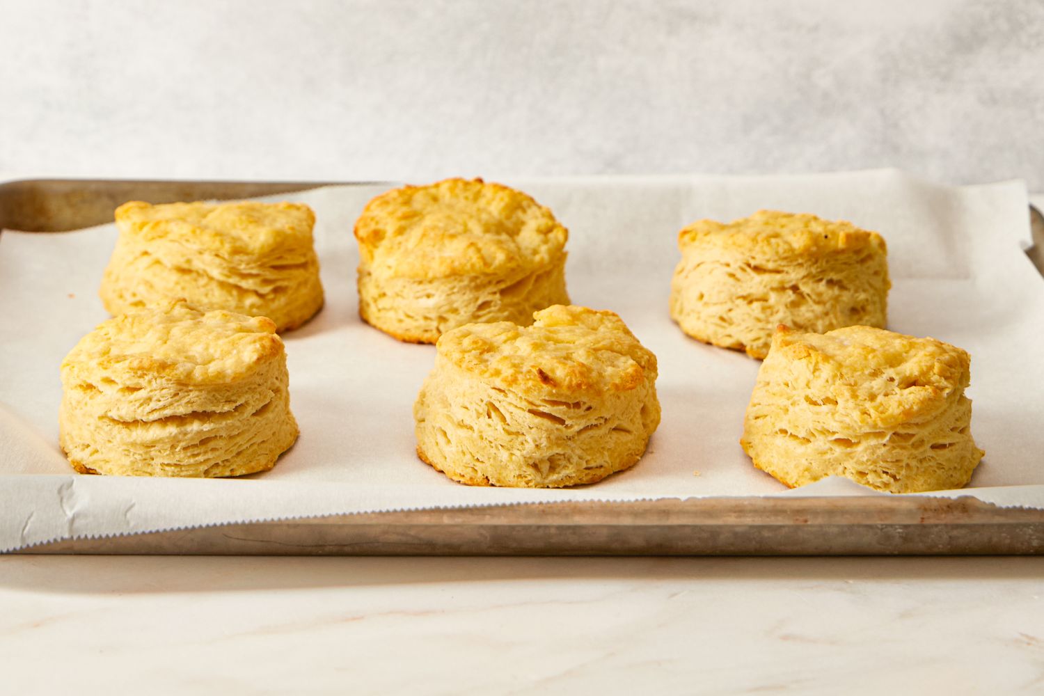 A tray of baked biscuits arranged on parchment paper