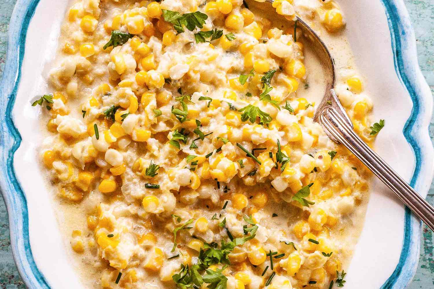 A serving spoon with homemade cream corn inside.