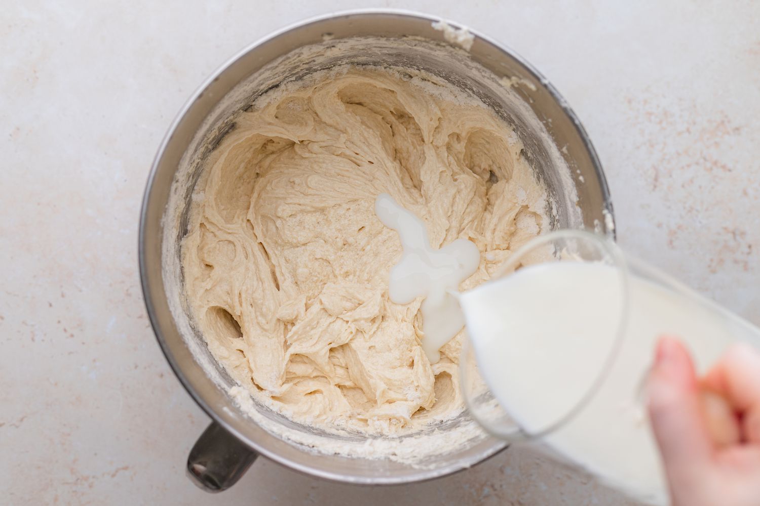 Adding Milk to Rainbow Layer Cake Batter in a Mixing Bowl