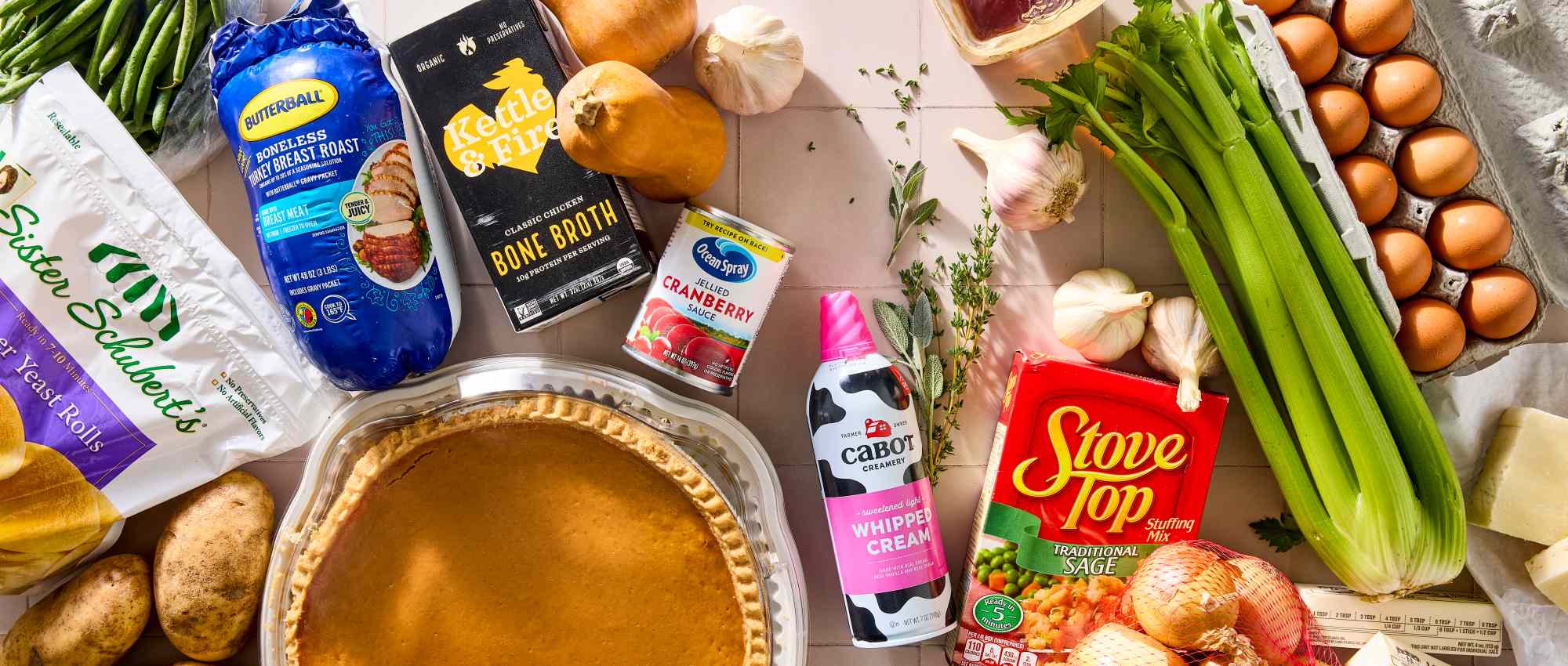 Thanksgiving meal ingredients including pie canned cranberry stuffing mix vegetables and whipped cream