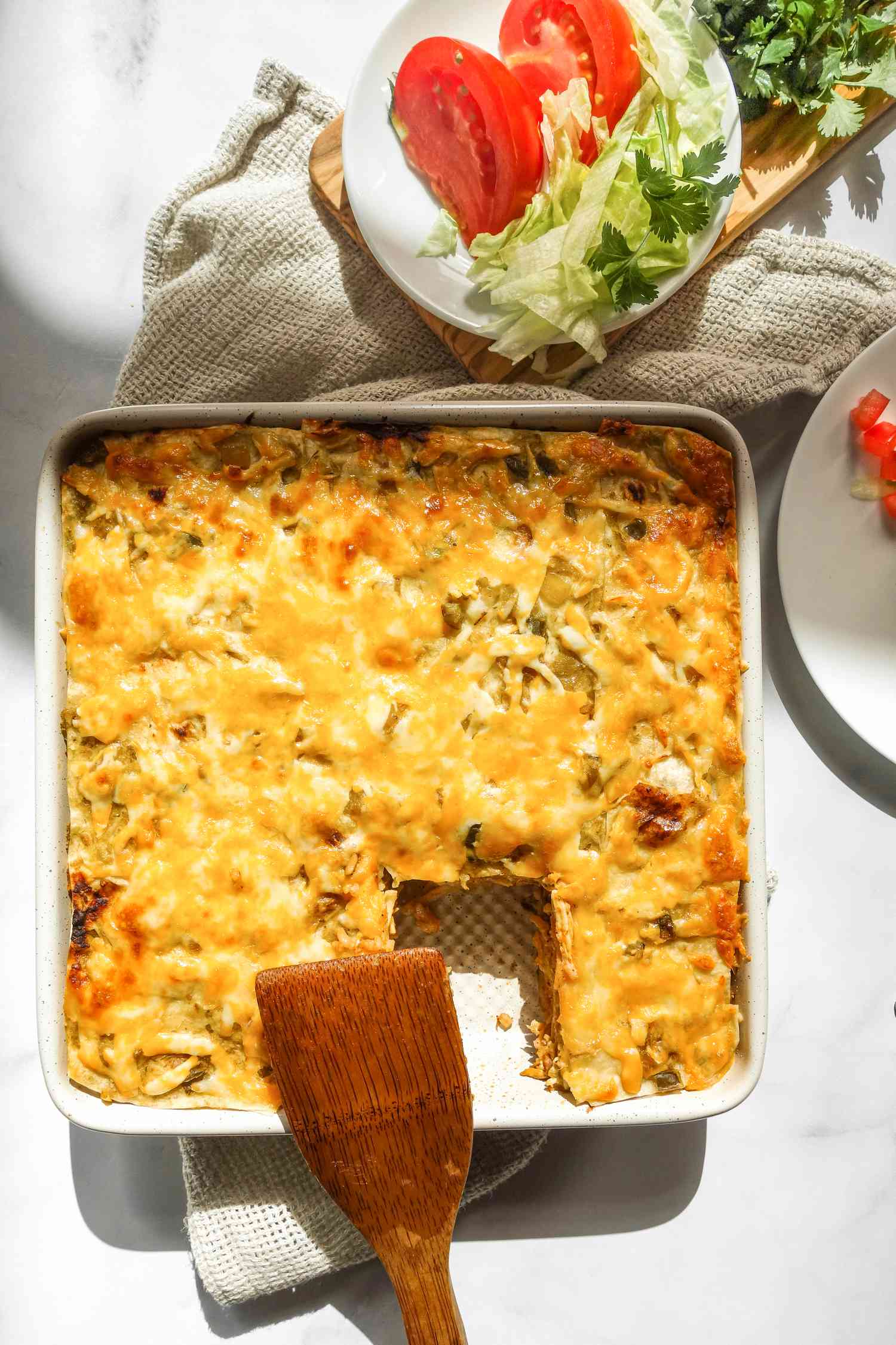 Burrito casserole in dish with lettuce and tomatoes.