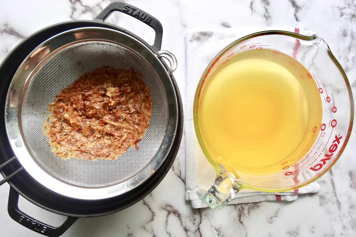 Straining dashi and liquid in a measuring glass for homemade miso.