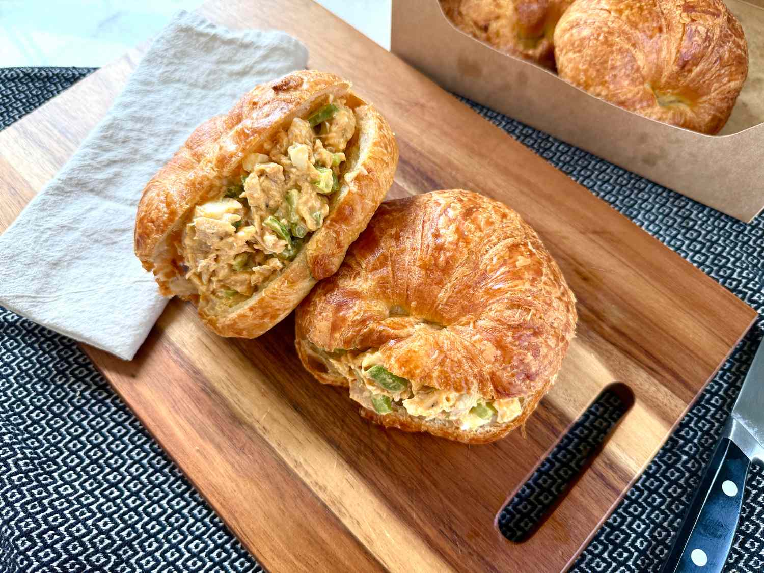 Kardea Brown's Chicken Salad Sandwiches on croissants on a wooden board with a napkin