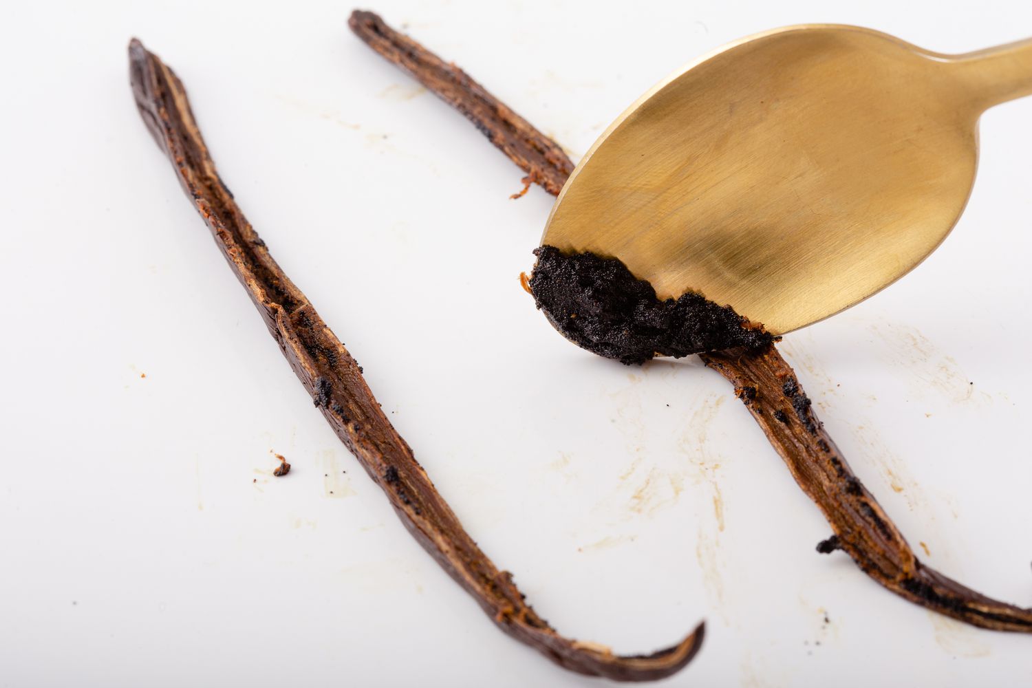 Scraping a vanilla bean with a spoon to show how to make cupcakes.
