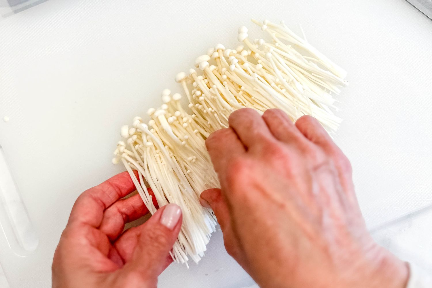 Enoki mushrooms (with roots removed) separated into individual pieces for budae jjigae (army base soup) recipe