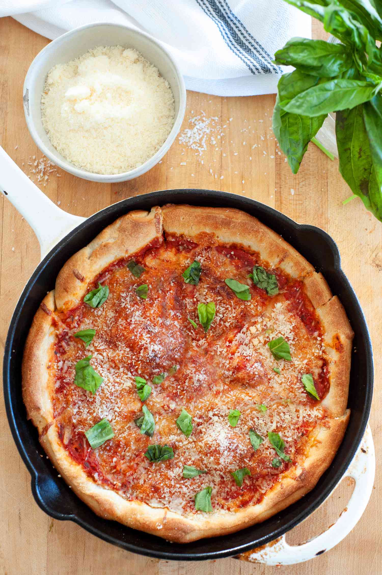 Cast iron pizza with parmesan and basil.