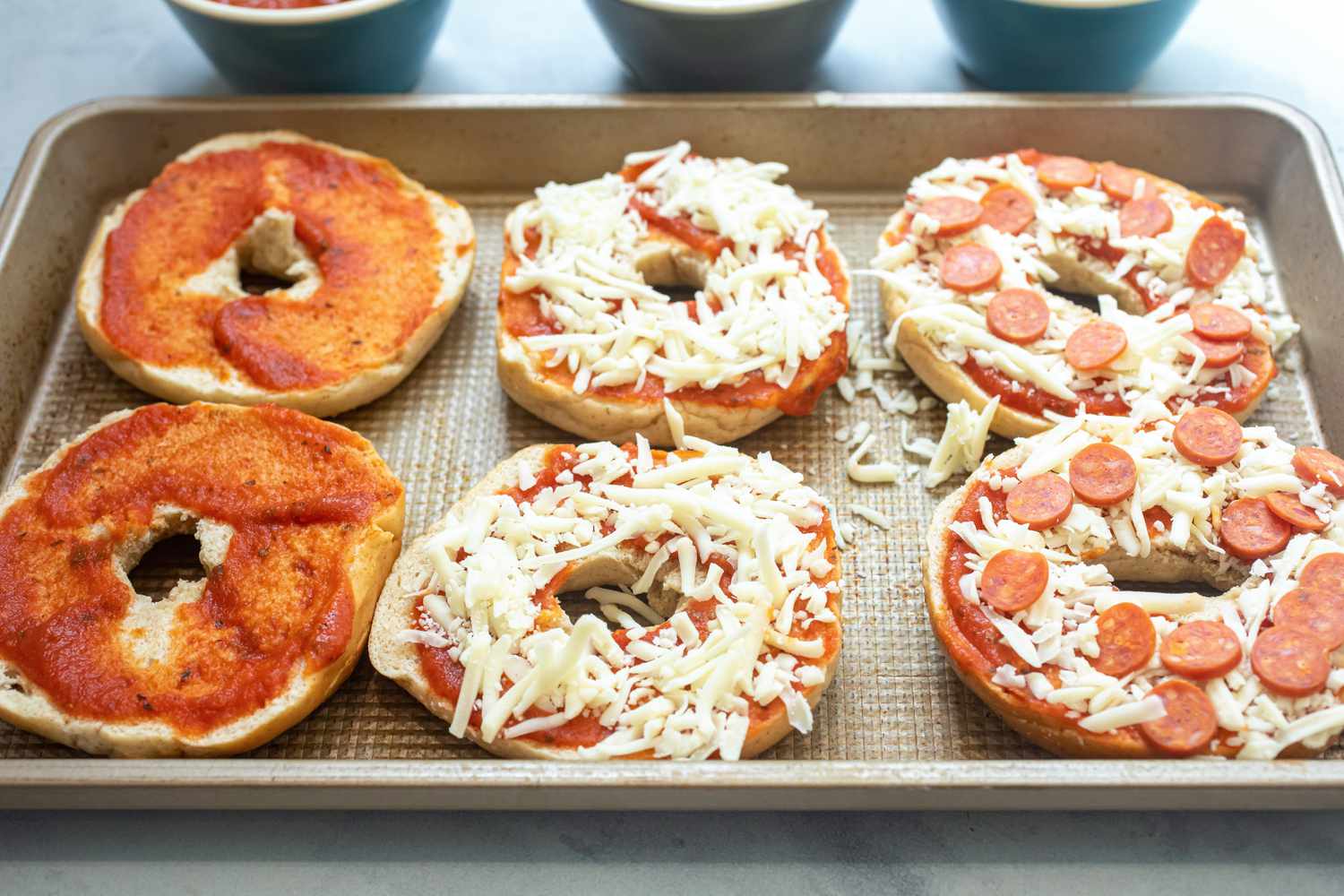 Bagel halves topped with sauce, cheese, and pepperoni.