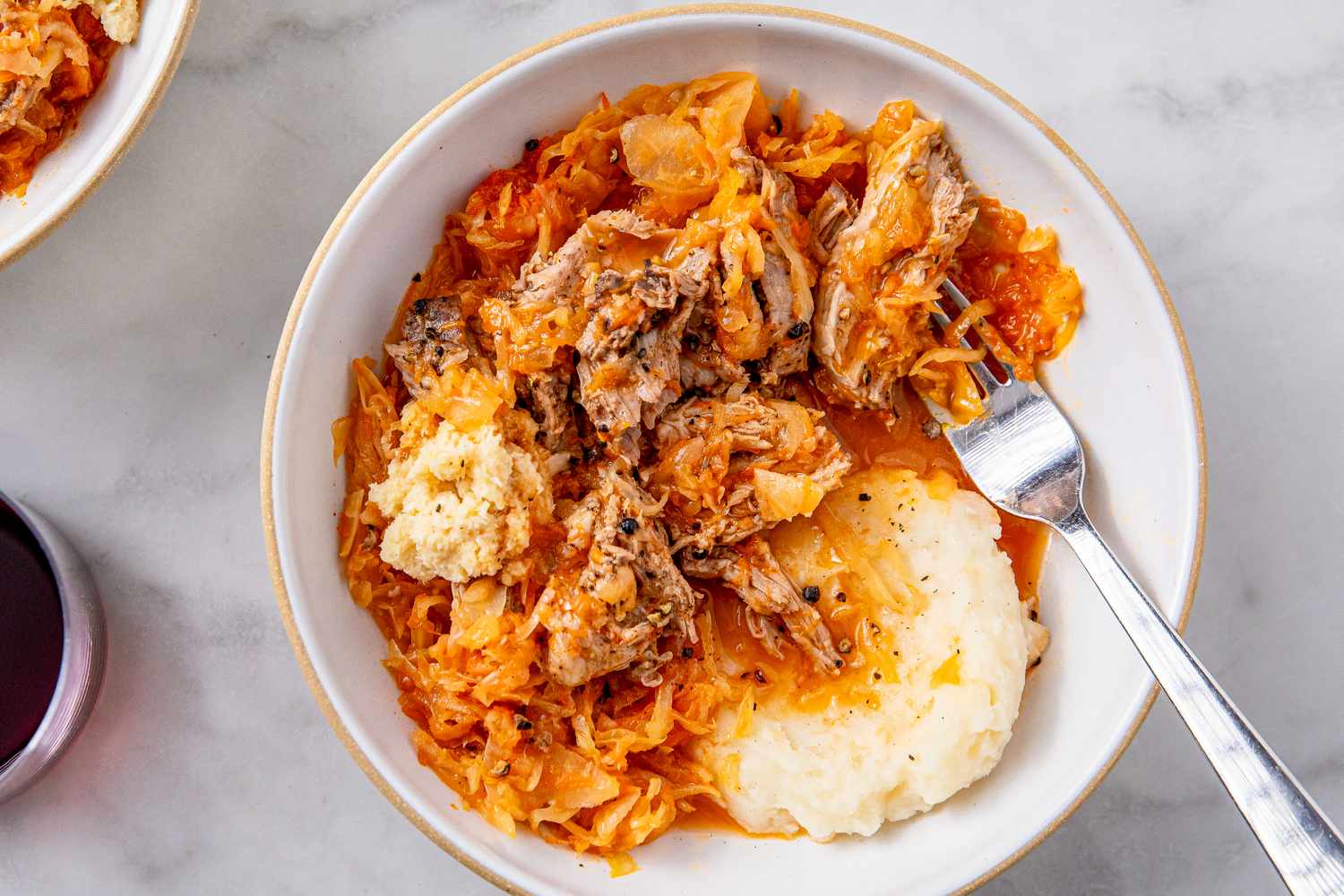 Braised pork roast with sauerkraut served on a plate with a side of mashed potatoes