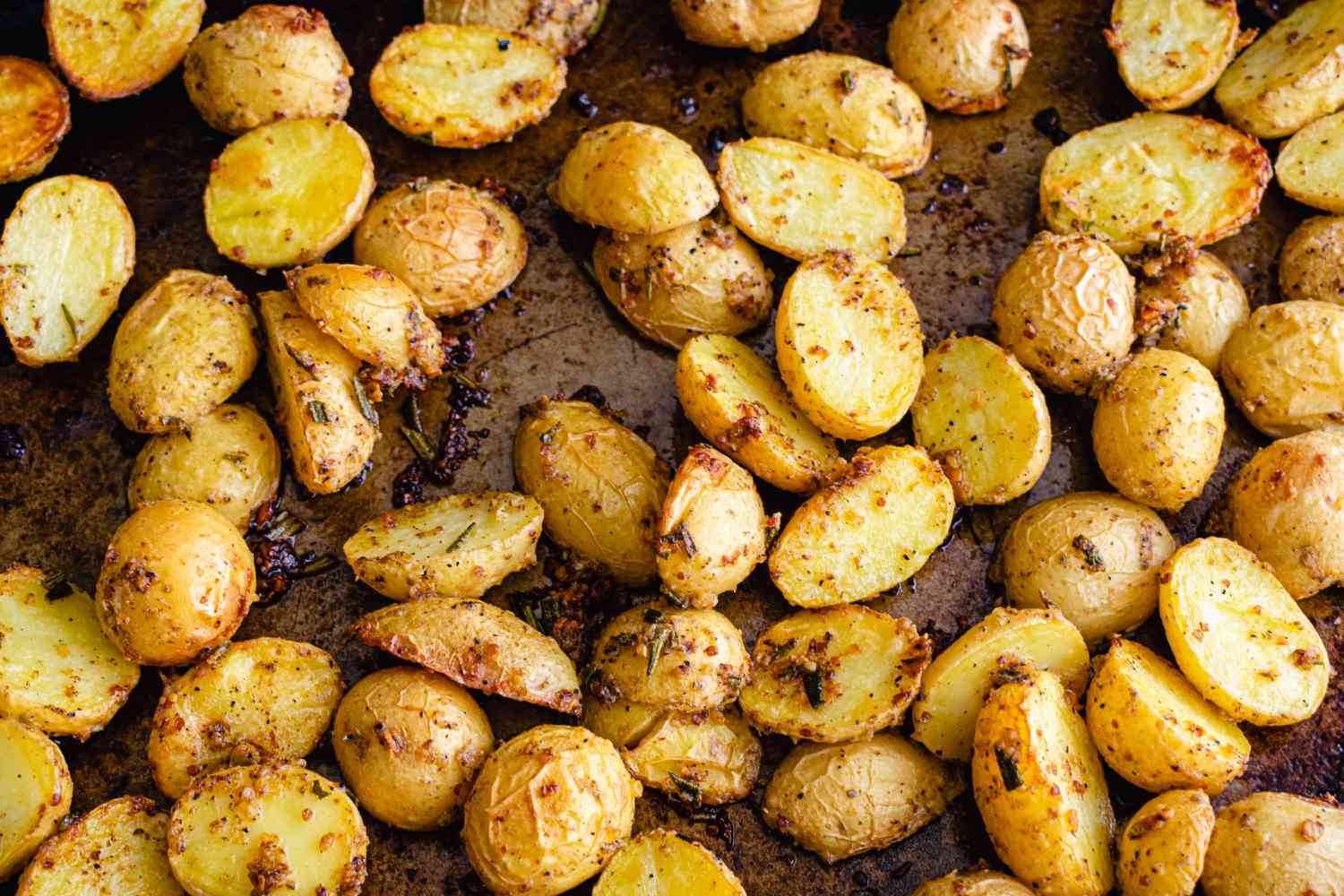 halved yellow potatoes seasoned and roasted on a sheet pan