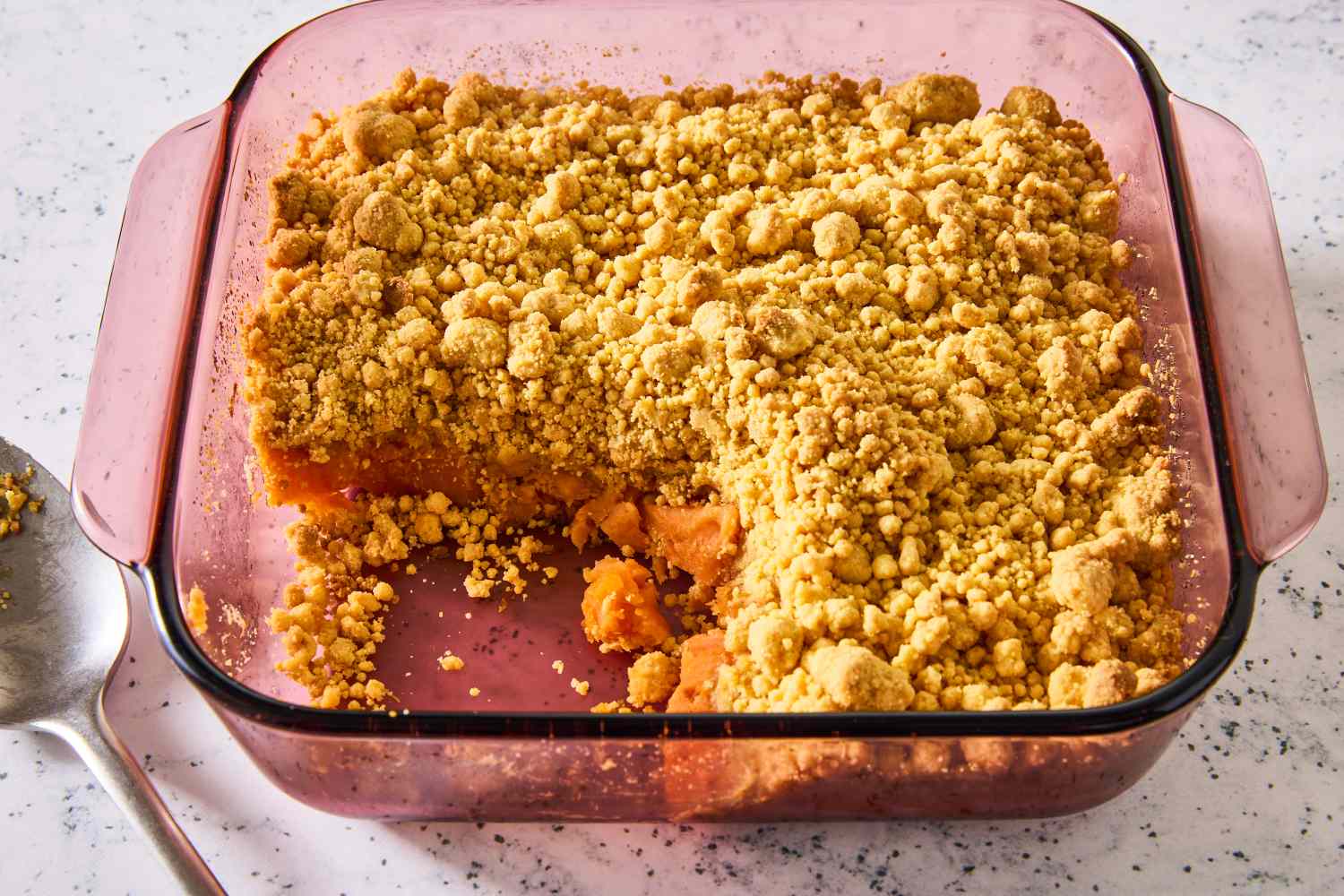 baking dish of 4-Ingredient Sweet Potato Dump Cake, one serving scooped out