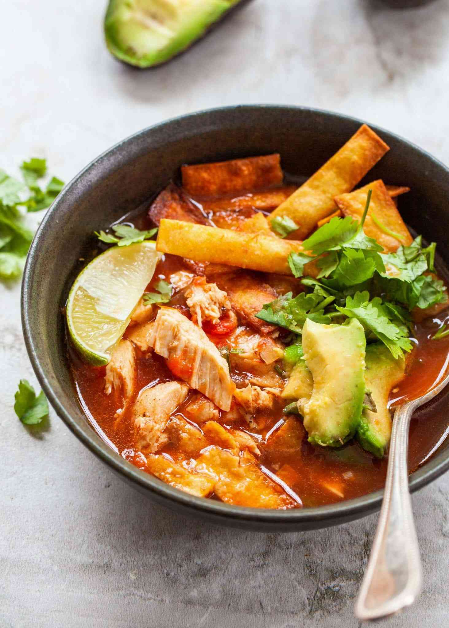 chicken tortilla soup in bowl with spoo